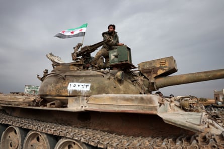 Syrian soldiers ride a tank as they replace Kurdish forces in Maskanah in northern Syria