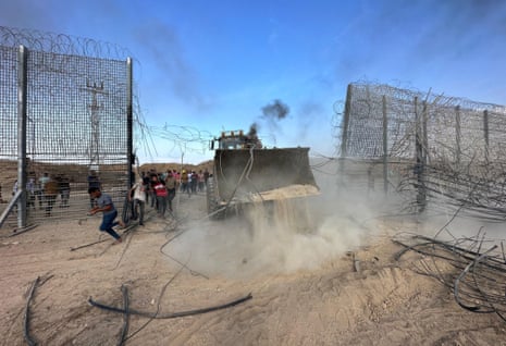 A bulldozer at a border fence