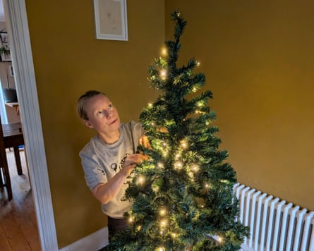 Jane is seen arranging the foliage on a pre-lit Christmas tree