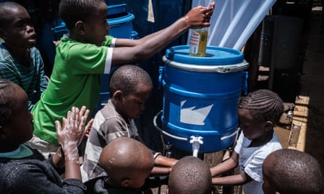 Children learn how to wash hands to prevent the spread of Covid at one of the hand washing stations installed by local NGO Shining Hope for Communities (Shofco) at Kibera slum in Nairobi, March 2020