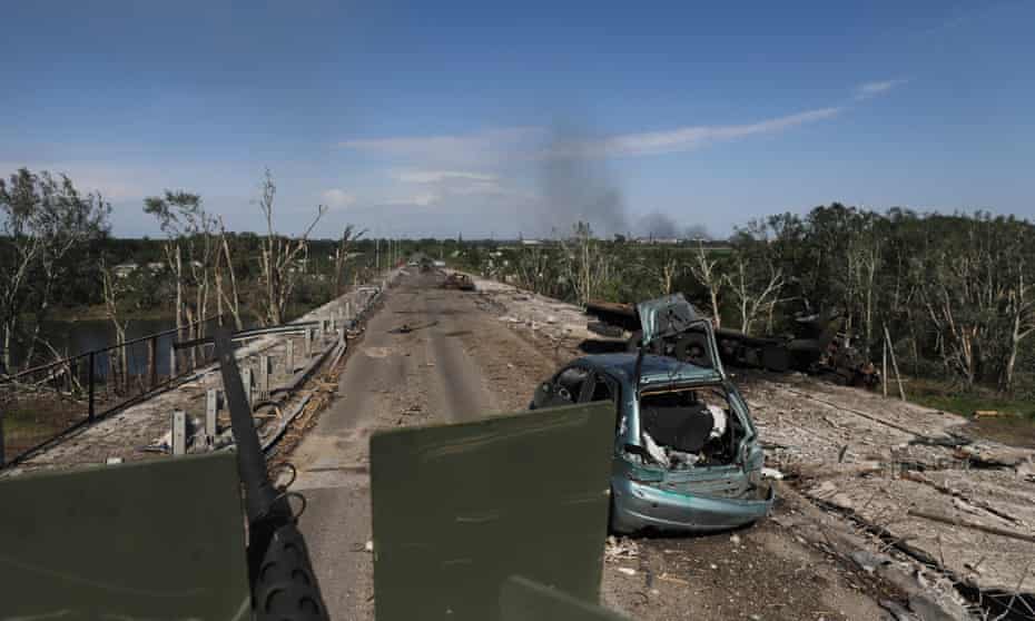A Ukrainian APC passes a destroyed car near the frontline in Sievierodonetsk.