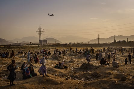 A military transport plane launches off while Afghans who cannot get into the airport to evacuate, watch and wonder while stranded outside, in Kabul, Afghanistan, on 23 August 2021.