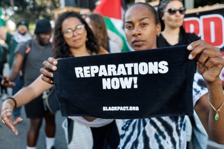 A protester displays sign that reads ‘Reparations Now!’