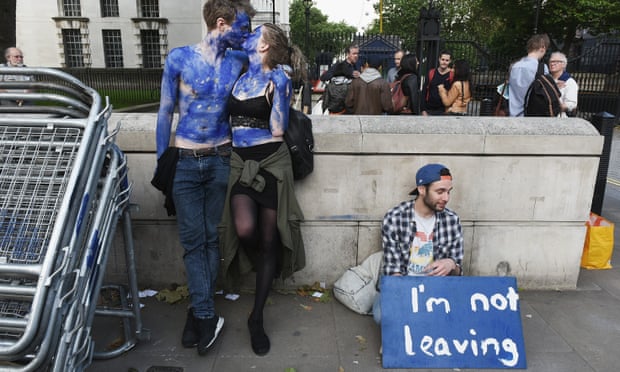 A young couple painted as EU flags and man with a sign saying 'I'm not leaving',  protest outside Downing Street.