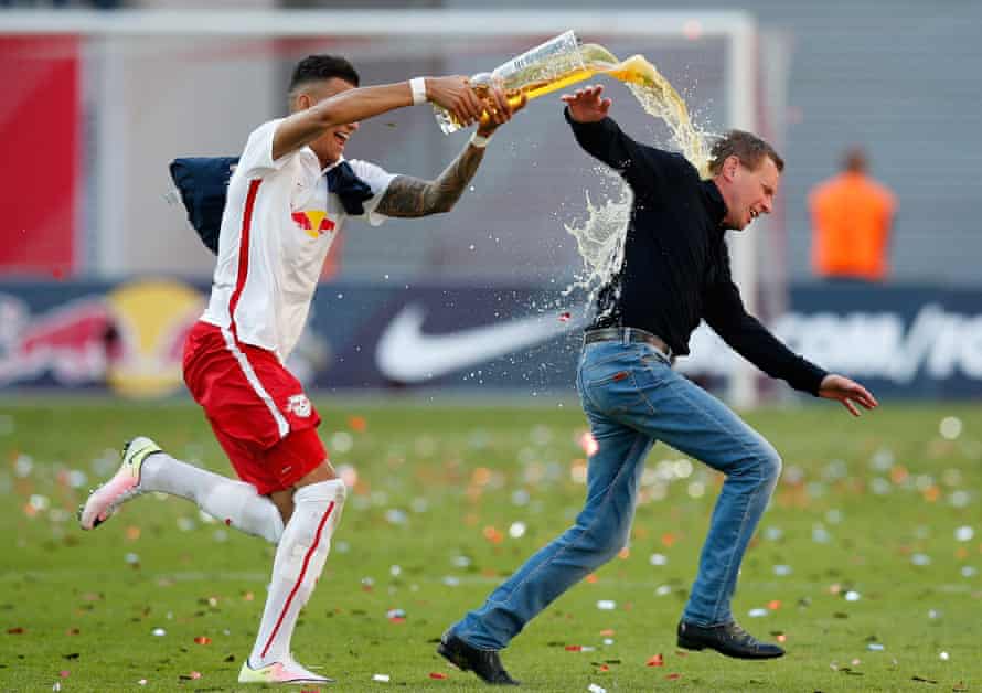 Davie Selke showers RB Leipzig head coach Ralf Rangnick with beer while celebrating promotion to the top flight.