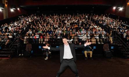 Dallas Jenkins at the premiere of The Chosen’s fifth season in Sao Paulo, Brazil, with his hands spread out and an audience waving their hands behind him.