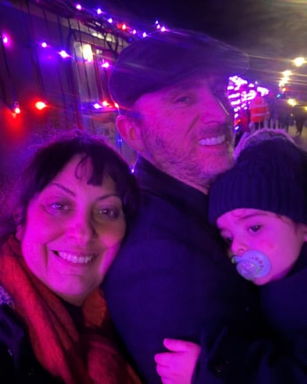 A snapshot of the McKinneys with their son Zak, taken at night, with lights behind them.