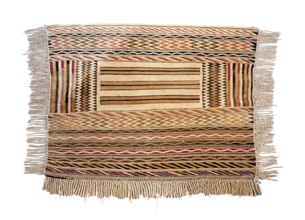 A blanket woven from woolly dog hair and goat wool which has colorful horizontal and vertical lines.