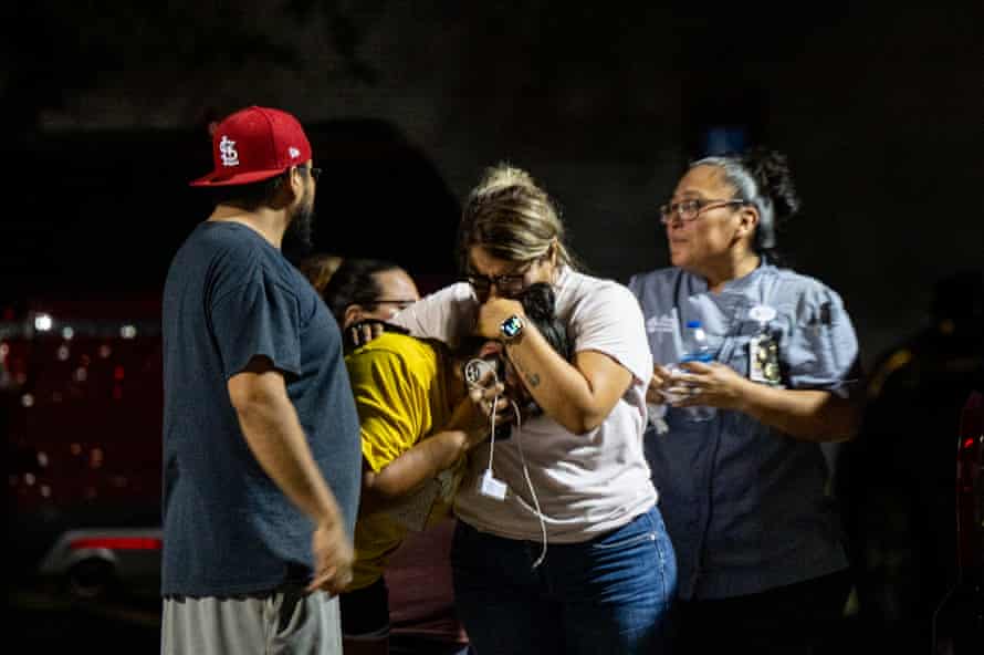A family holds each other as night falls.