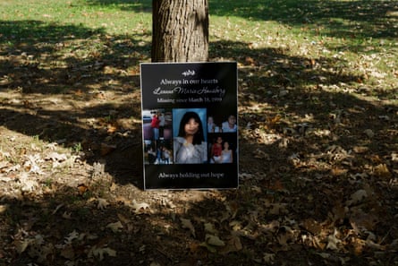 A memorial poster with photographs of Leanne propped up against a tree.