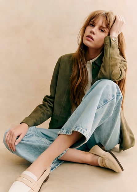 Model wearing khaki suede jacket, white shirt and pale blue jeans