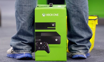 A man stands over his new Xbox One console.