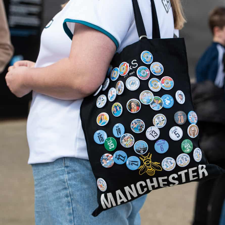 Manchester City fan Charlotte with her Tote bag decorated with Man City badges.