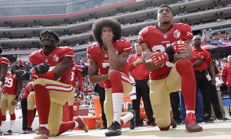 Colin Kaepernick takes a knee flanked by Eli Harold (left) and Eric Reid (right)