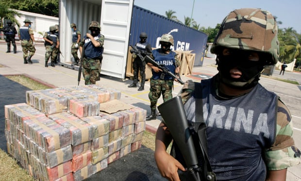 A marine stands guard near packs of cocaine at a naval base in Manzanillo.