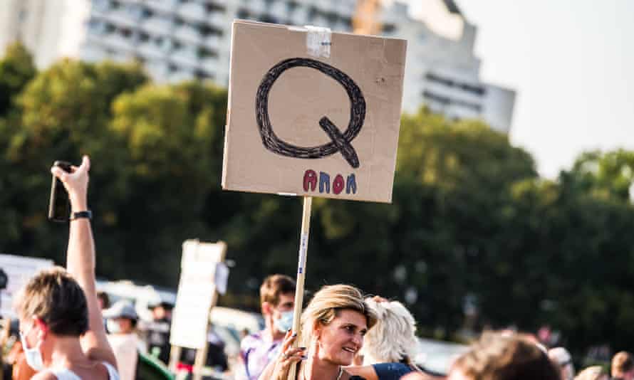 A protester holds a QAnon sign at a demonstration in Germany