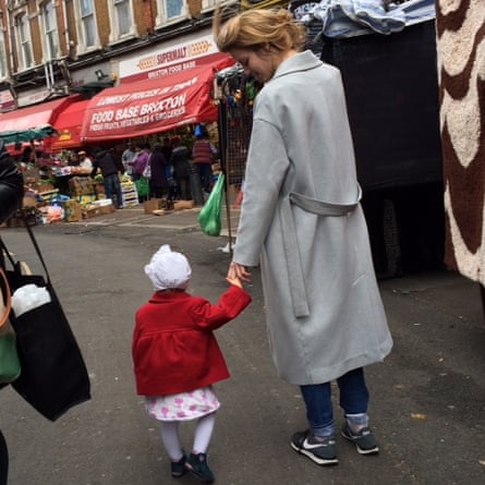 Jedidajah Otte holding the hand of her small child in a street