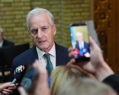 Norway's PM Jonas Gahr Støre speaks as microphones and a phone camera are held up
