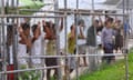 Asylum-seekers look through a fence at the Manus Island detention centre in Papua New Guinea March 21, 2014. 