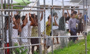 Asylum-seekers look through a fence at the Manus Island detention centre in Papua New Guinea March 21, 2014. Faces pixellated at source. Picture taken March 21, 2014. Eoin Blackwell/AAP/via REUTERS ATTENTION EDITORS - THIS PICTURE WAS PROVIDED BY A THIRD PARTY. EDITORIAL USE ONLY. NO RESALES. NO ARCHIVE. AUSTRALIA OUT. NEW ZEALAND OUT