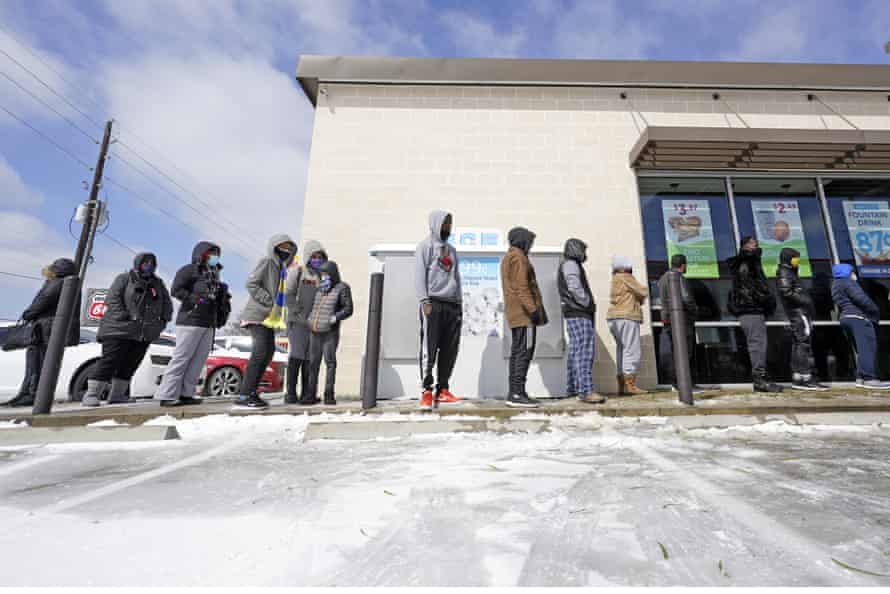 People wait in line to buy groceries Monday in Houston.
