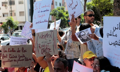 Activists hold signs in solidarity with Hajar Raissouni during a protest outside the Rabat tribunal.