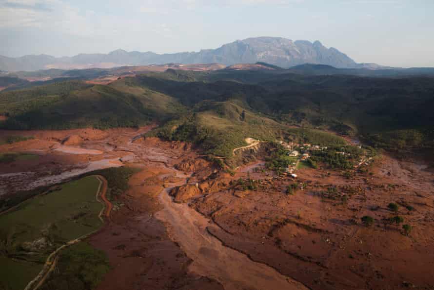 Vista aérea de detritos e lama ao longo de um vale após o rompimento das barragens