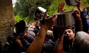 Arms held aloft above a crowd holding up pans