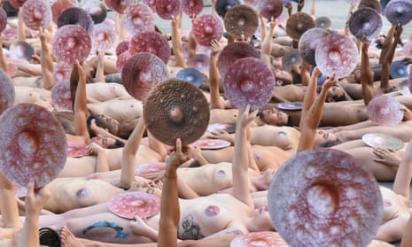 People pose nude holding cut outs of nipples during a photo shoot by the artist Spencer Tunick on Monday in New York.