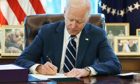 Joe Biden signs the American Rescue Plan on 11 March 11, 2021, in the Oval Office.