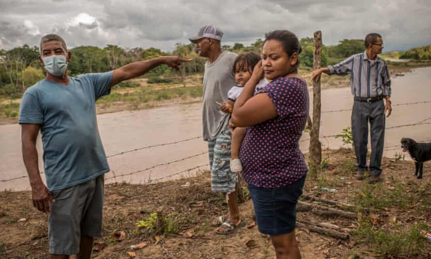 Sharlyu Alegria Hernandez, 38 (center-right), spokeswoman for the neighborhood association, with other community members on the shore of Aguan river. Like all her neighbors of Chapagua, was forced to leave her home due to the flood caused by the Eta and Iota storm, late 2020. Chapagua village, Trujillo, Colon, Honduras. Octuber 17, 2021. People of Bajo Aguan, a region of Honduras' department of Colon, besides historic social conflict due to contended land ownership between peasant communities and powerful oligarchy families who nowadays are exploiting land with huge oil palm plantations, they are also suffering from natural phenomena caused by climate change. In the last decades, several storms and hurricanes affected millions of people, mostly among the highest vulnerable villages around Aguan river. Latest hurricanes, Eta and Iota, late in 2020, flooded several villages and many families had to leave their homes.