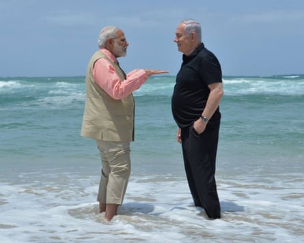 Modi and Netanyahu stand in the sea smiling together at a demo of a mobile desalination unit