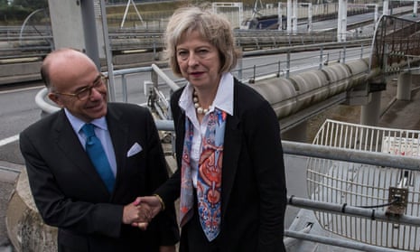 French minister of the interior Bernard Cazeneuve and his British counterpart Theresa May shake hands at the Eurotunnel terminal in Calais.