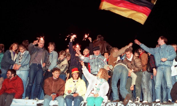 Young east Berliners celebrate on top of the Berlin Wall in 1989.