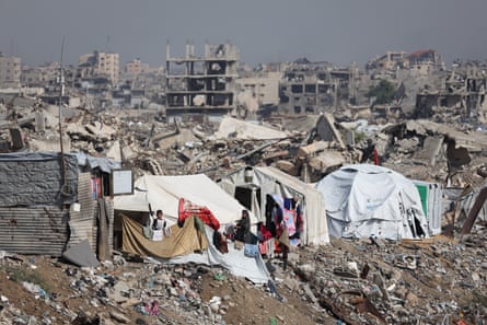 People setting up tents amid rubble in Gaza City.
