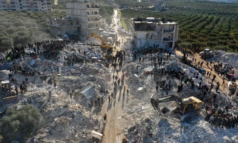 An aerial picture shows rescuers searching the rubble of buildings for casualties and survivors in the village of Besnaya in Syria’s rebel-held northwestern Idlib province.