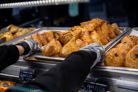 An worker places a tray of caller pastries successful a basking nutrient bar