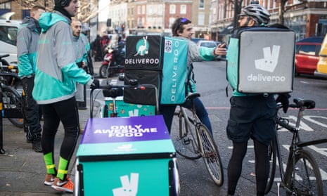 Deliveroo cycle couriers wait for orders in London.