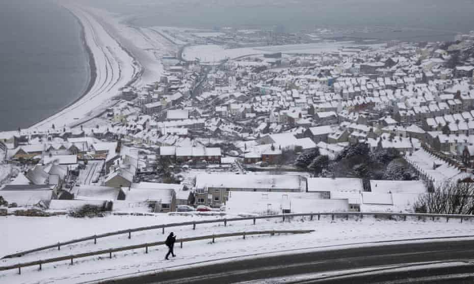 A man walks down a hill in Portland, England, after the ‘mini beast from the East’ on 18 March.