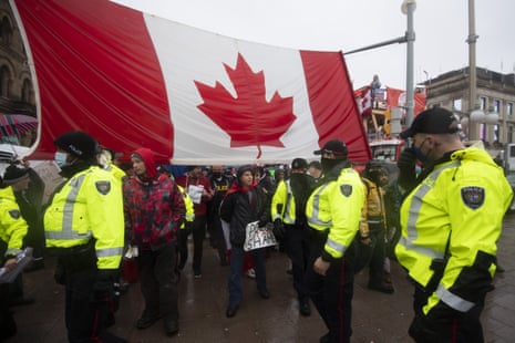 Police are followed by yelling protesters as they attempt to hand out a notices to protesters in Ottawa, on Thursday.
