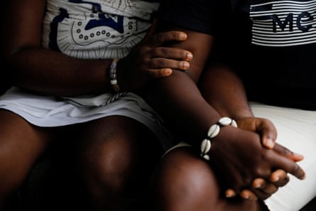 Two seated women hold hands