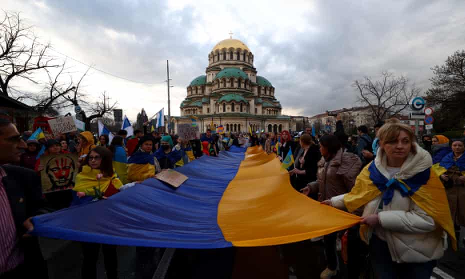 People in Sofia demonstrate holding Ukraine’s national flag during a march in support of Ukraine