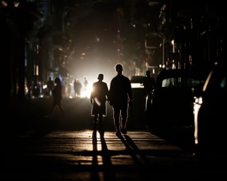 హవానాలో విద్యుత్ అంతరాయం ఏర్పడిన సమయంలో రోడ్డు మధ్యలో సిల్హౌట్లో ఉన్న వ్యక్తులు