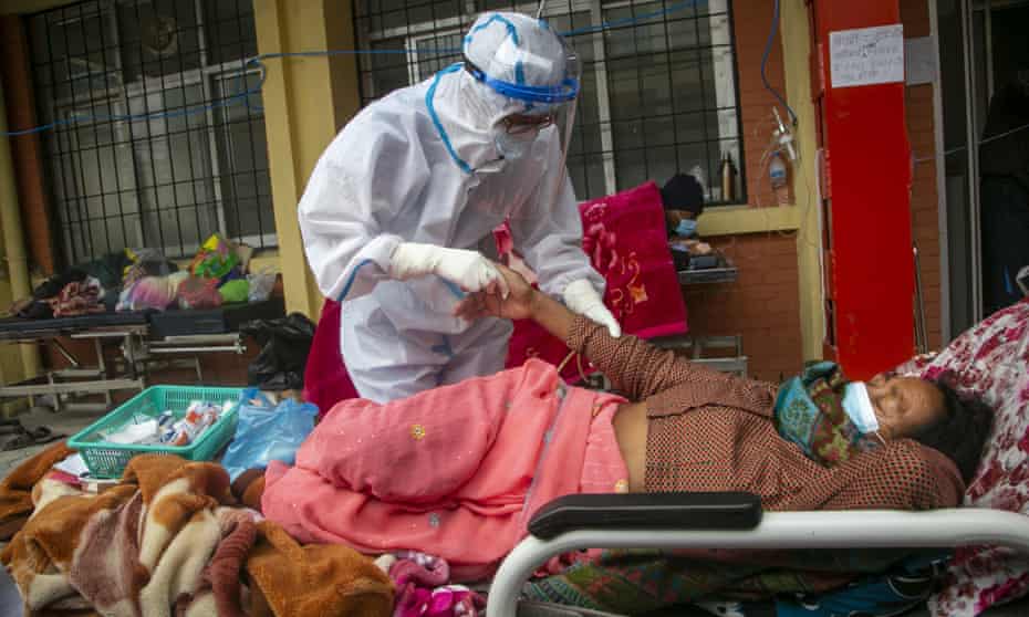 Nepalese paramedics treat a Covid-19 patient outside a hospital in Kathmandu, Nepal.