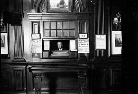 A black and white photo of a man in a box office in an old-fashioned theatre in January 1924