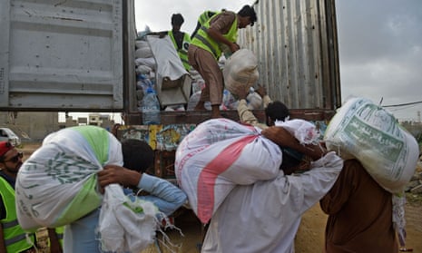 Volunteers load relief food bags on a truck for flood-affected people in Karachi, Pakistan, on Sunday.