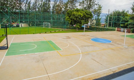 A sports court outside with a volleyball net set up in the centre