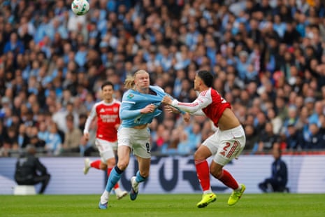Erling Haaland tussles with William Saliba