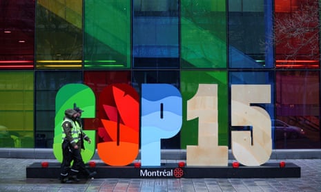 Police officers walk past a sign as they patrol outside the Palais des congrès de Montréal during the opening of Cop15,  the two-week U.N. biodiversity summit.