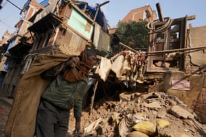 Scrap collector walks past ruined building in Kathmandu, Nepal